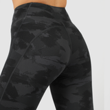 a a back view for woman wearing camo legging ,the background is light grey 