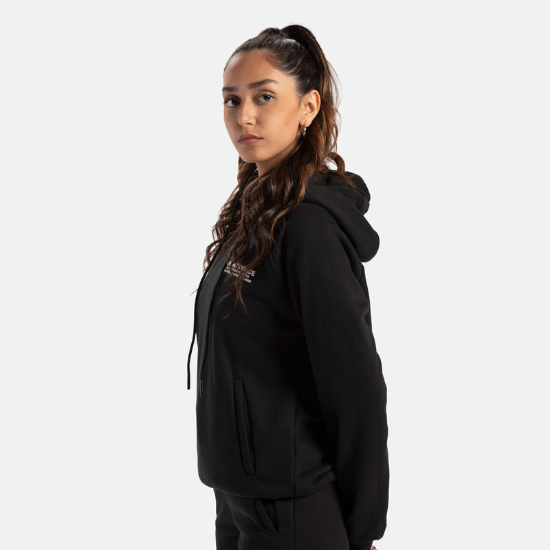 a fit woman stand at right and wearing t-shirt black  with pants black 