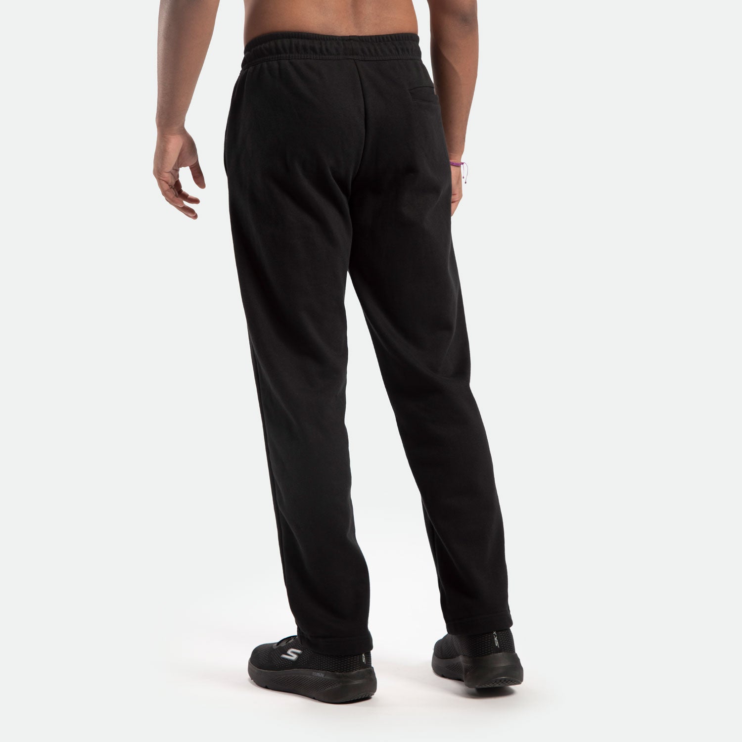 a back view for fit man wearing pants black with shoes 
