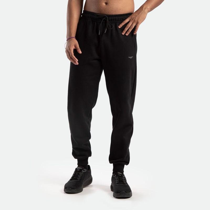a fit man wearing jogger pants black with logo ,plus the shoes black 