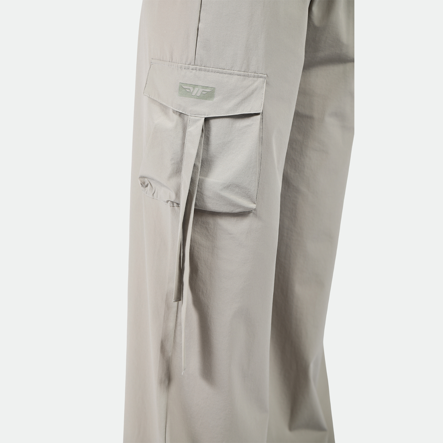 close up view for pocket of pant with logo plus the background is light grey 