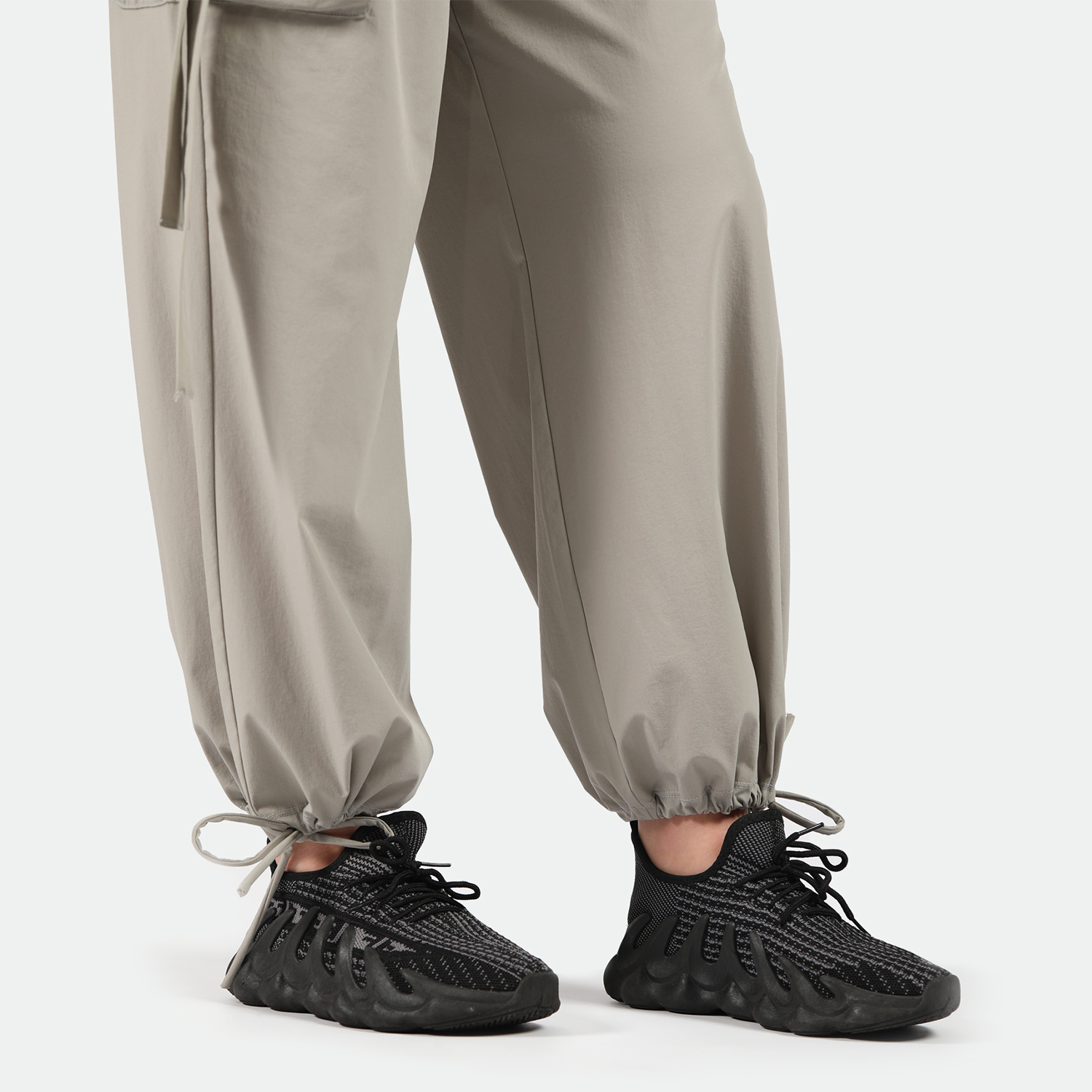 close up view for fit woman wearing pants beige with sneakers  black 
