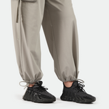 close up view for fit woman wearing pants beige with sneakers  black 