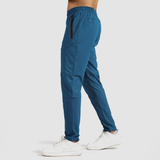a fit man stand at right and wearing pants classic blue  with shoes white 