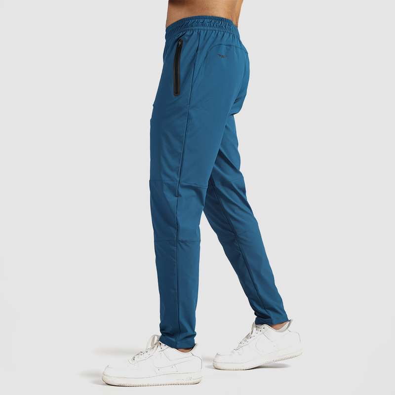 a fit man stand at right and wearing pants classic blue  with shoes white 
