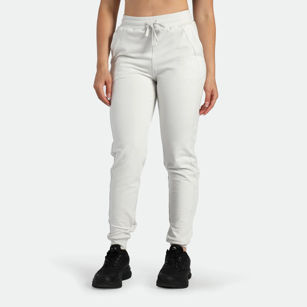 a fit woman wearing jogger pants cloud grey ,plus the shoes black 