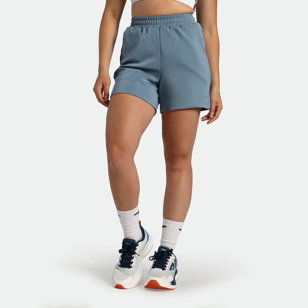 Person wearing light blue athletic shorts on a white background
