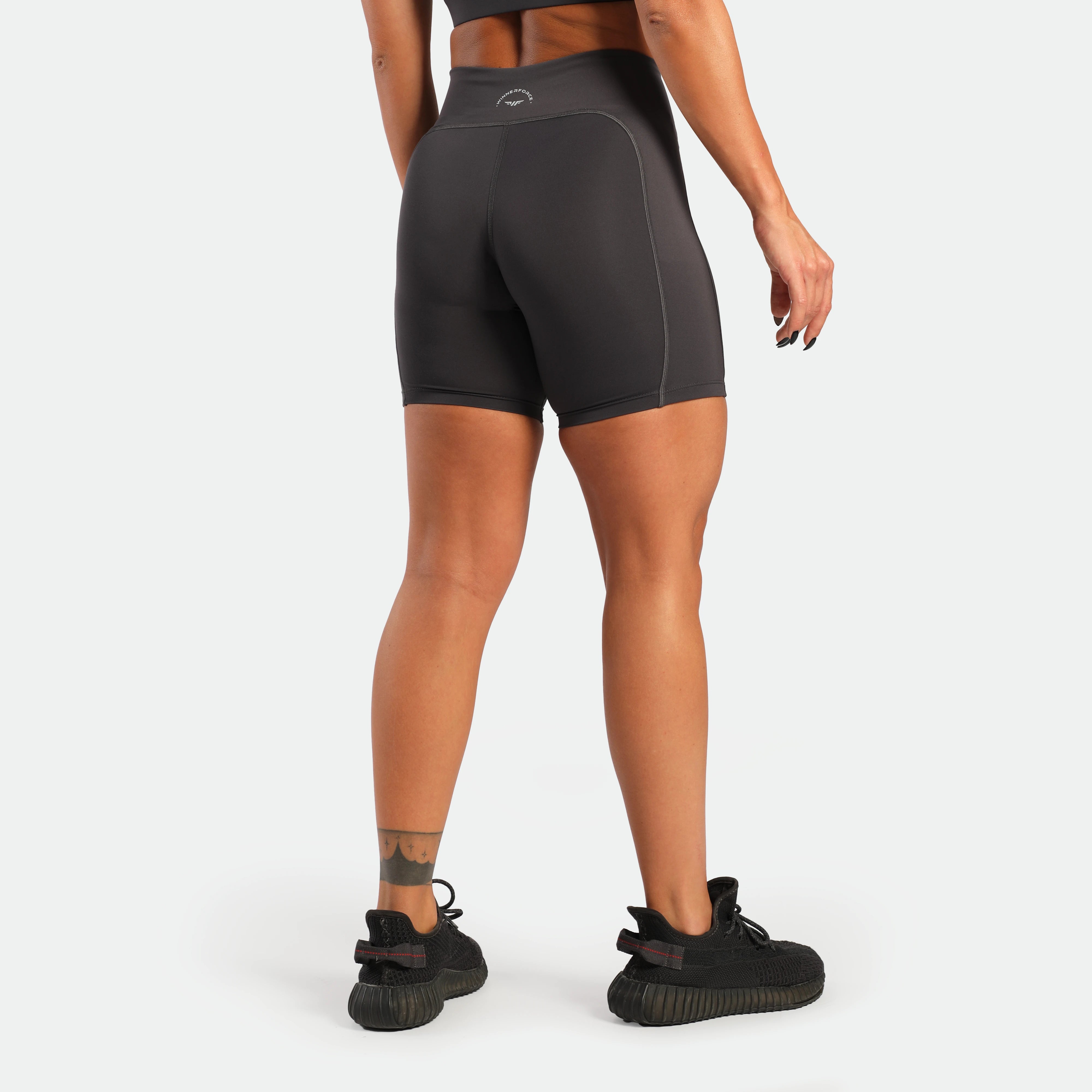 Person wearing black athletic shorts on a white background