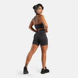 Woman wearing a black athletic outfit on a white background