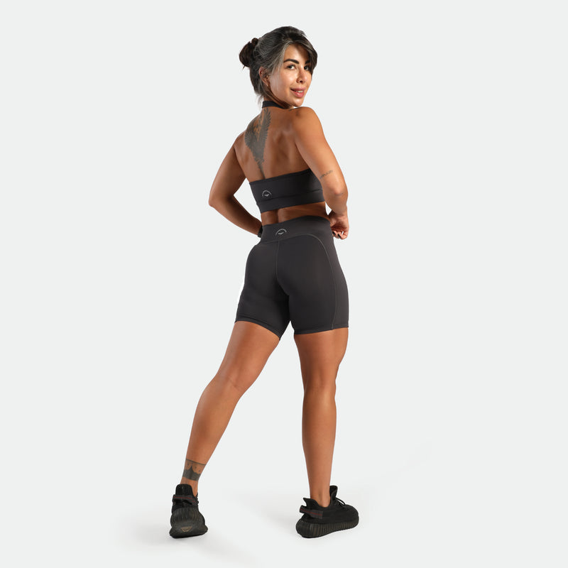 Woman wearing a black athletic outfit on a white background