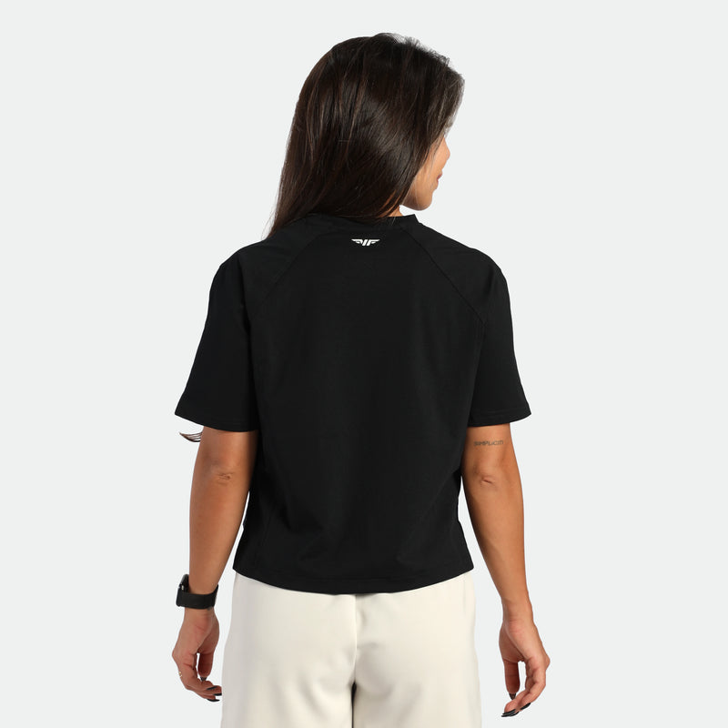Person wearing a black t-shirt with a logo on the back against a white background