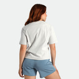 Woman wearing a light gray t-shirt and blue shorts on a white background