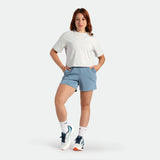 Person wearing a white t-shirt and light blue shorts on a white background