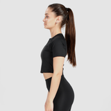 a fit woman stand at right and wearing crop top with legging  black 