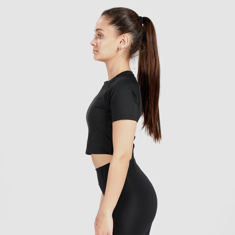 a fit woman stand at right and wearing crop top with legging  black 