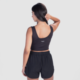 a back view for fit woman  wearing crop top  black  with logo  white and short black 