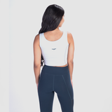  a back view for fit woman wearing  crop top white with logo and legging blue 