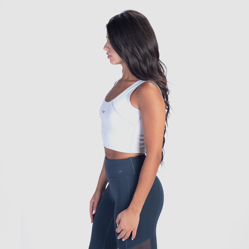 a fit woman stand at right and wearing crop top white with legging  blue 
