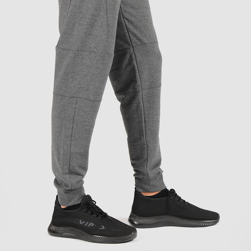 a fit man wearing pants marl light grey with shoes black 