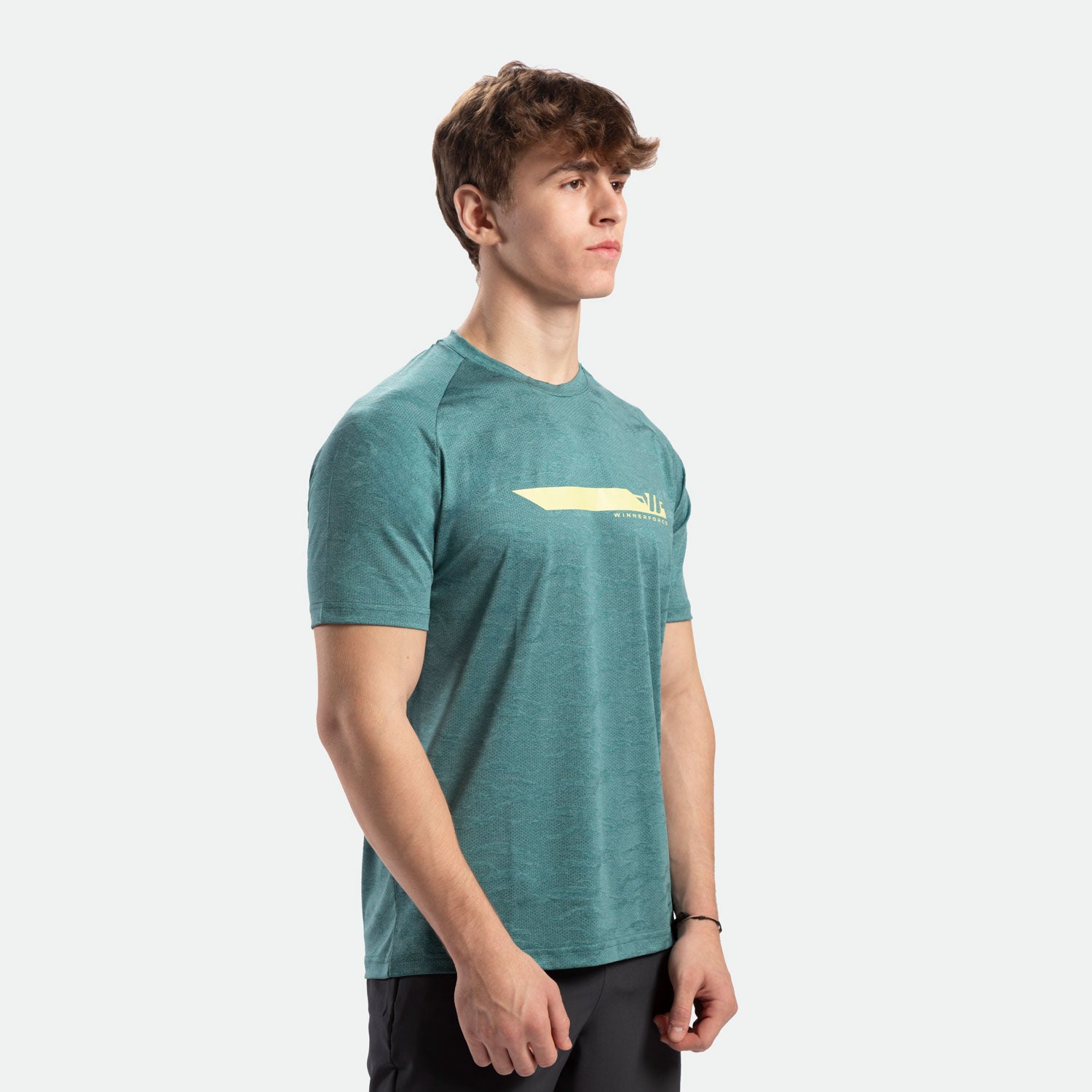 a fit man stand at right and wearing t-shirt DARK-CYAN with logo ,plus  pants black 