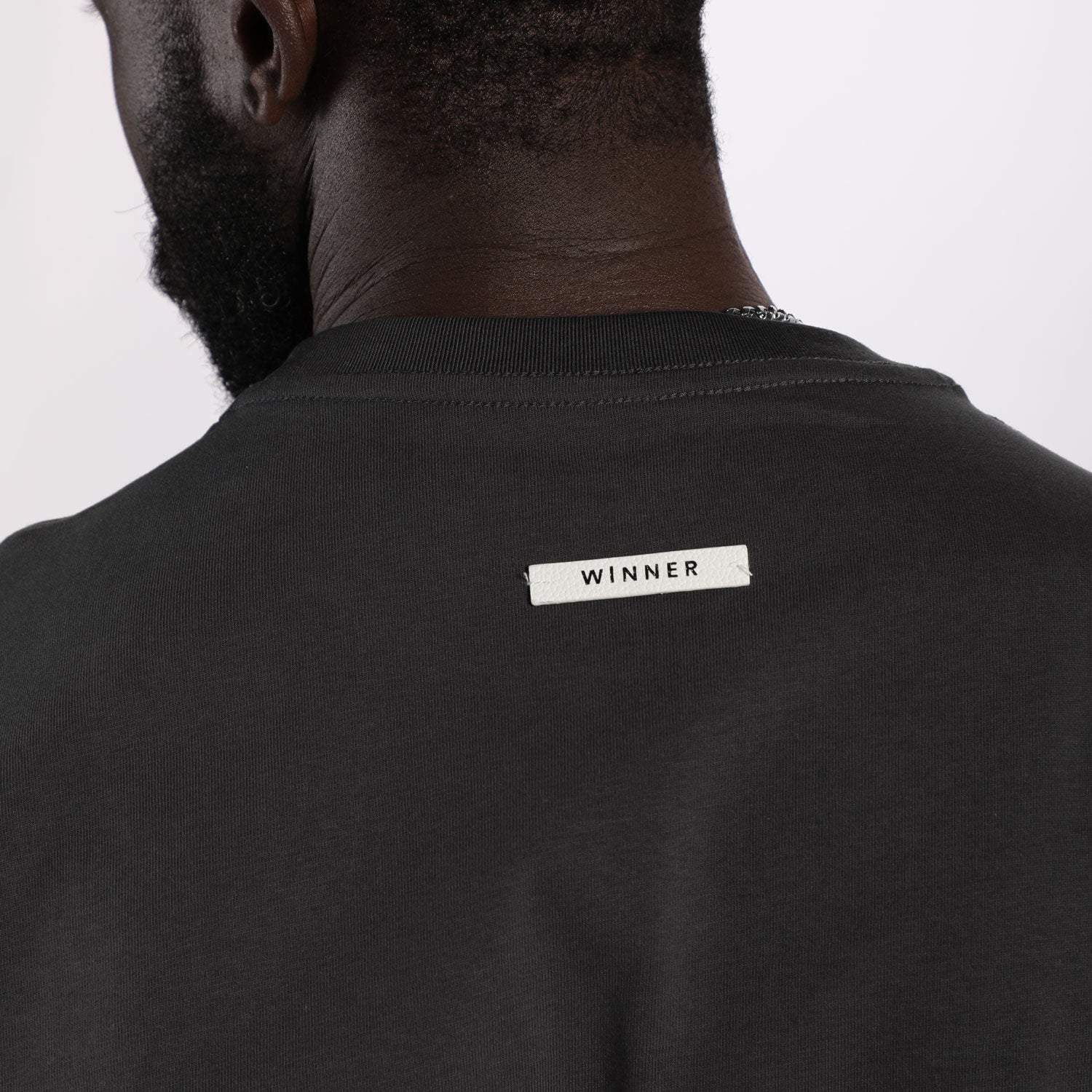 close up view for fit man wearing t-shirt dark grey  with logo