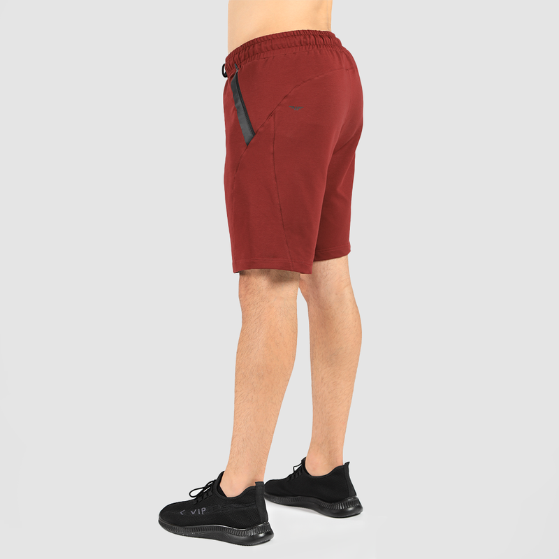a fit man stand at right and wearing short dark grey with shoes black 