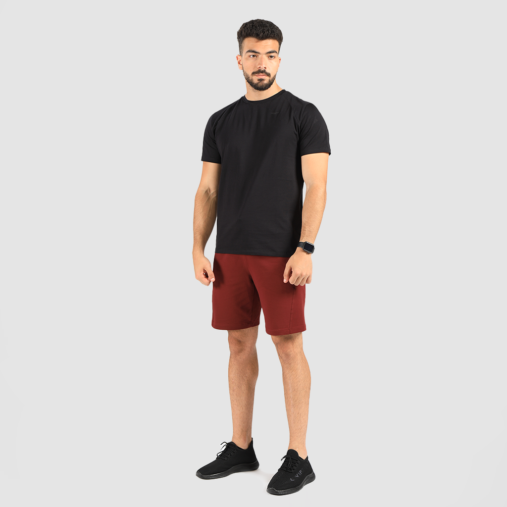 a fit man wearing t-shirt black with short dark red, plus shoes black 