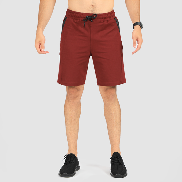 a fit man wearing short dark red with shoes black 