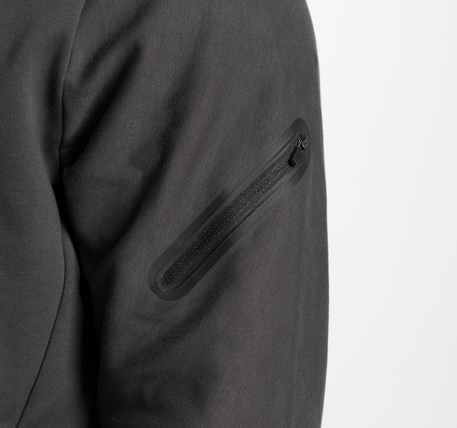 close up view for a person wearing ebony grey tech zipped hoodie with  pocket with zipped 
