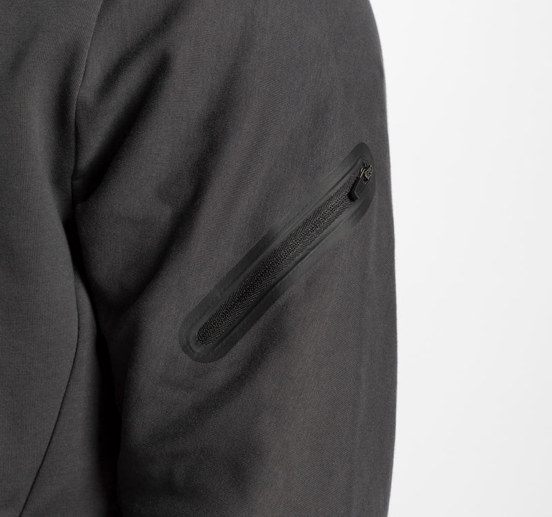 close up view for a person wearing ebony grey tech zipped hoodie with  pocket with zipped 