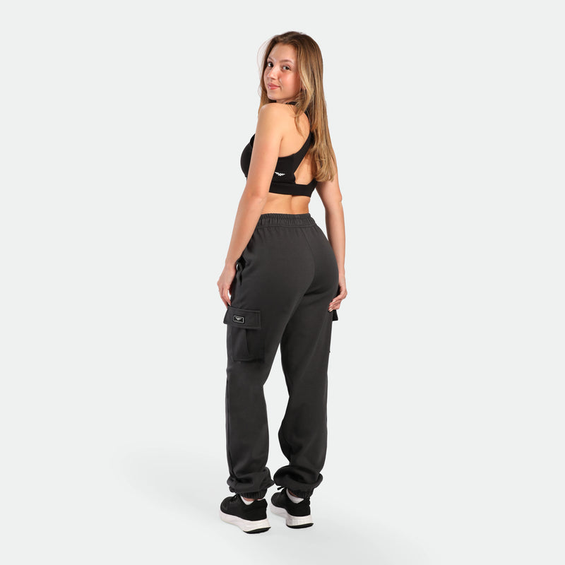 a back view for fit woman wearing  bra sports black with jogger pants ebony grey , plus the shoes black 