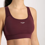 Woman wearing a bra, with the Winnerforce logo in white, holding the logo in half
