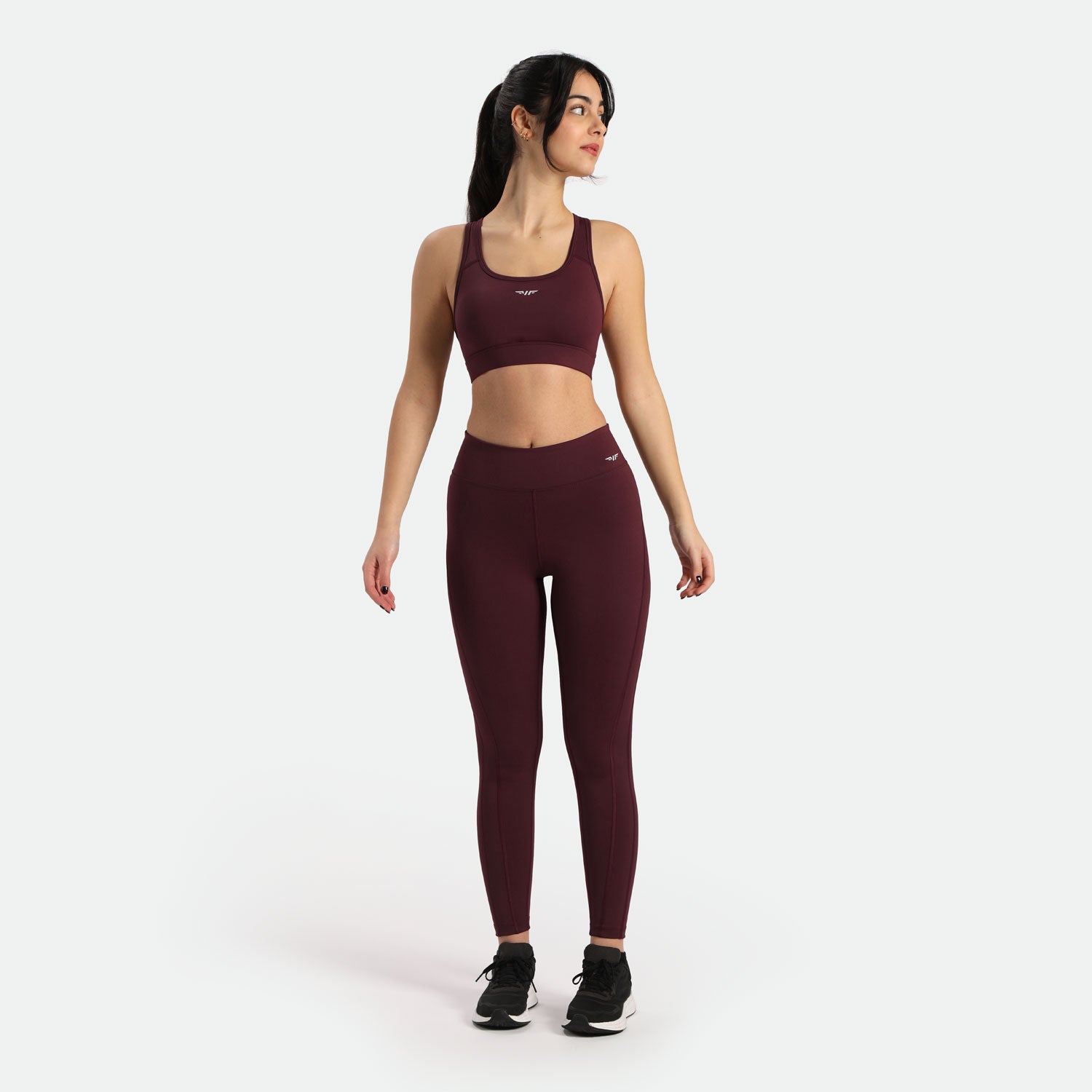  a fit woman wearing  matching bra  and legging red  with same logo white ,plus background  light grey 