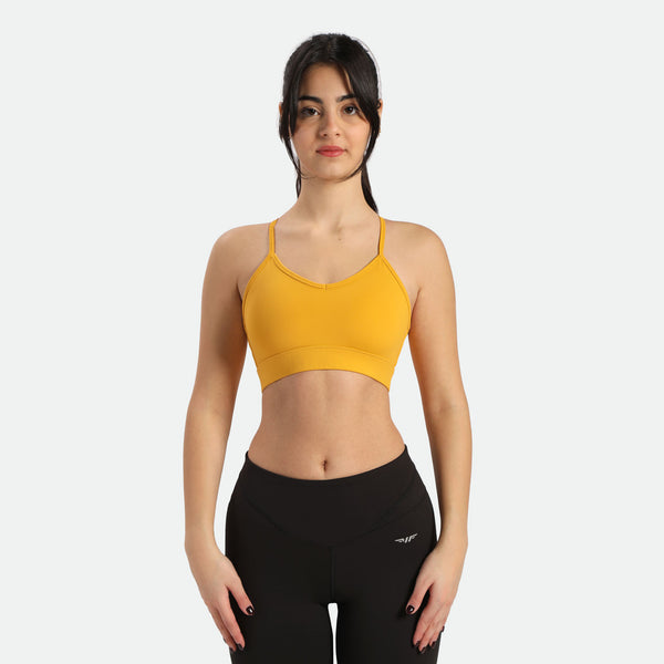 The woman has a fit body, wearing a yellow bra and black leggings, plus the leggings have the logo on them