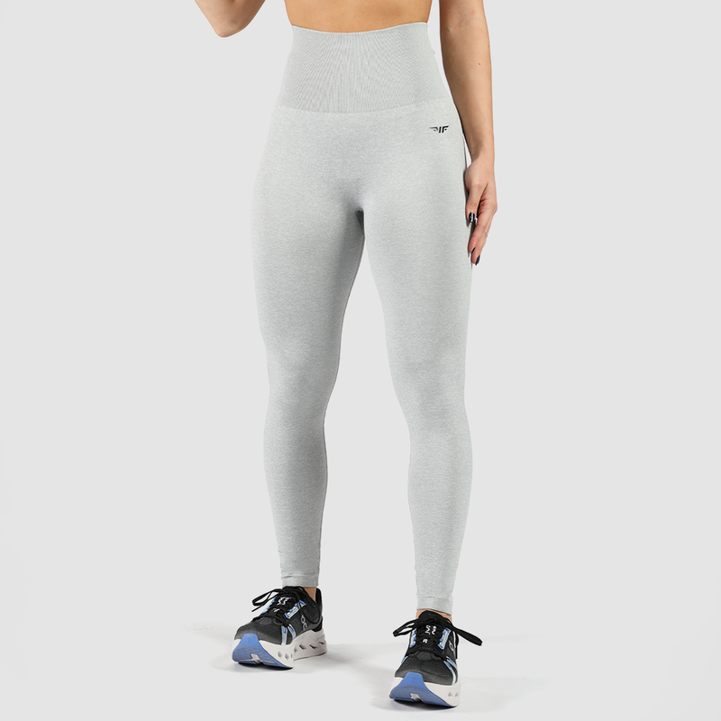a fit woman wearing legging grey with logo black and she wearing shoes ,plus the background is light grey 