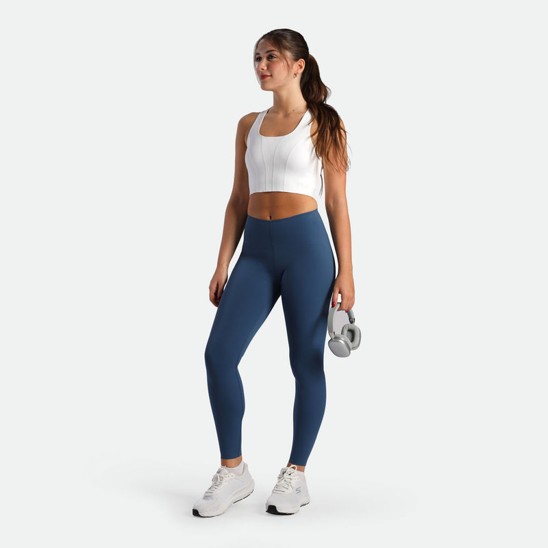 a fit woman wearing crop top white with legging ensign blue  plus the shoes white
