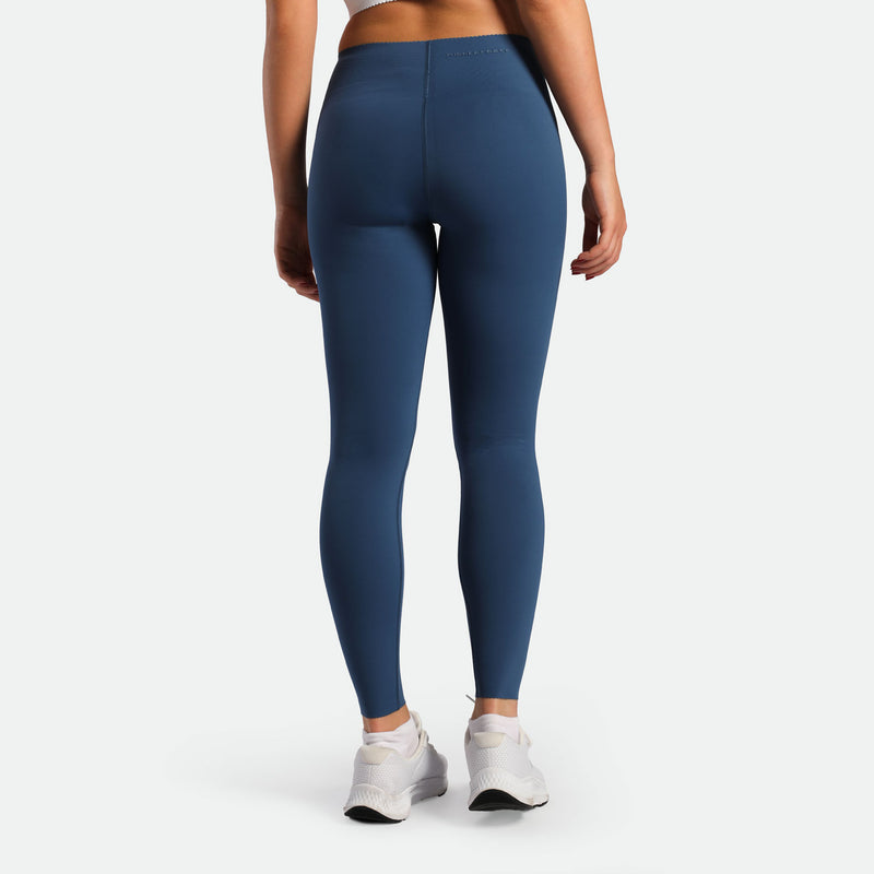 a back view for fit woman wearing legging  ensign blue with shoes white 