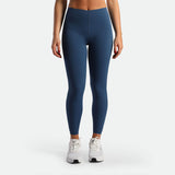 a fit woman wearing legging ensign blue ,plus the shoes white 