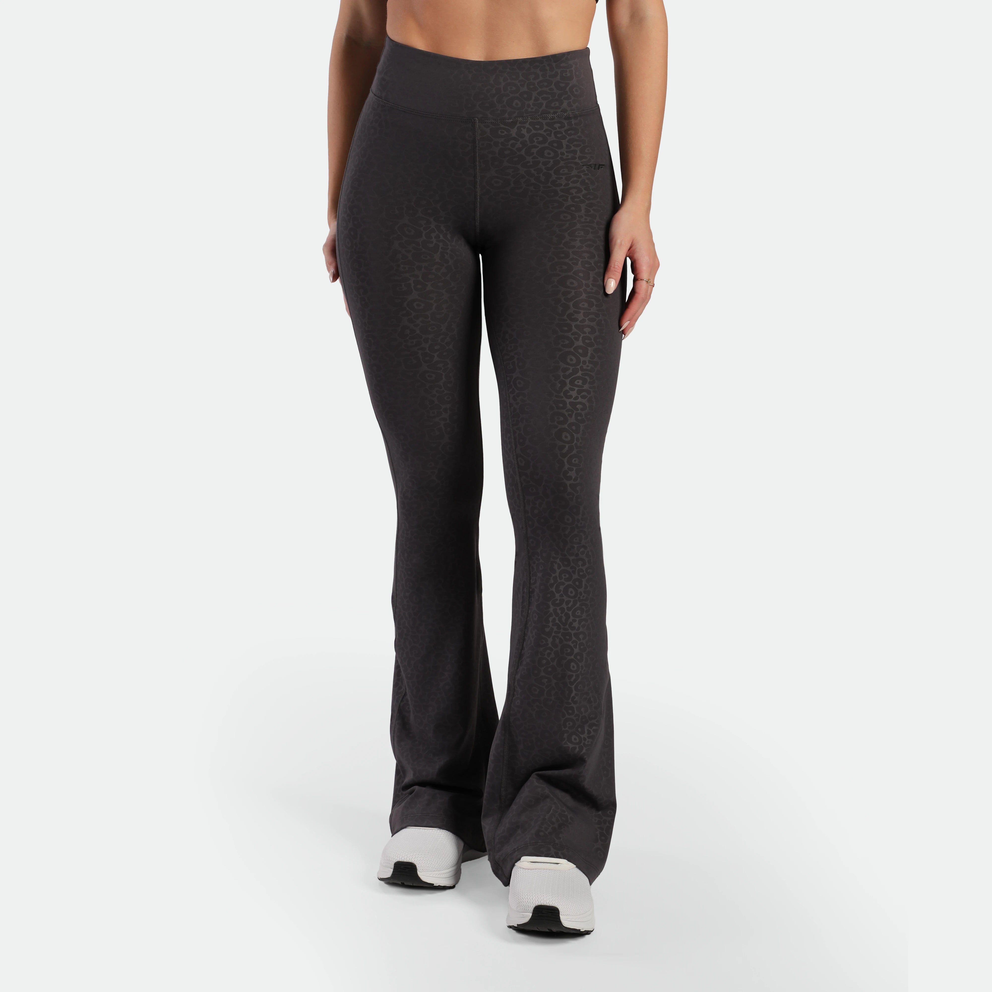 a fit woman wearing flared legging  
 graphite grey leopard with shoes 