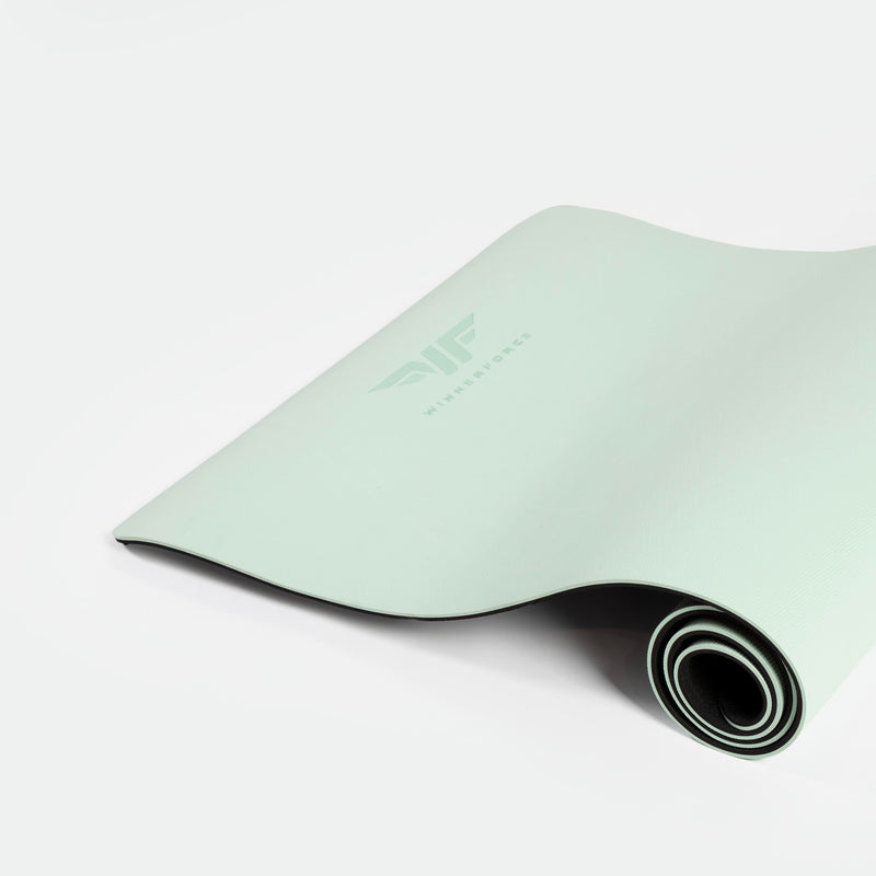 A mint-green yoga mat partially rolled out in a neat coil against a white background. The mat features a subtle logo, conveying a calm and fresh tone.