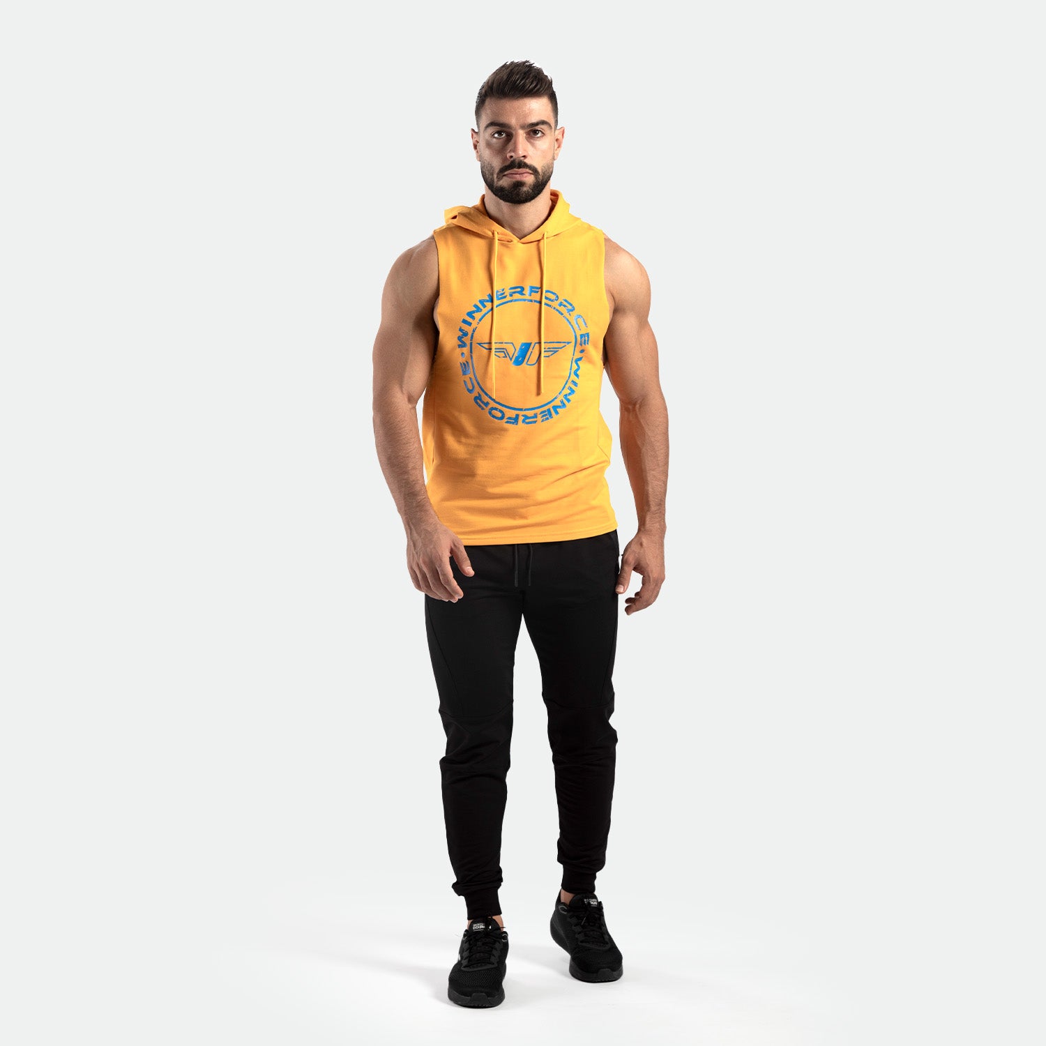 a fit man wearing half hoodie golden glow orange with pants black ,plus shoes black 