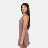 a fit woman stand at right and wearing dress purple 
