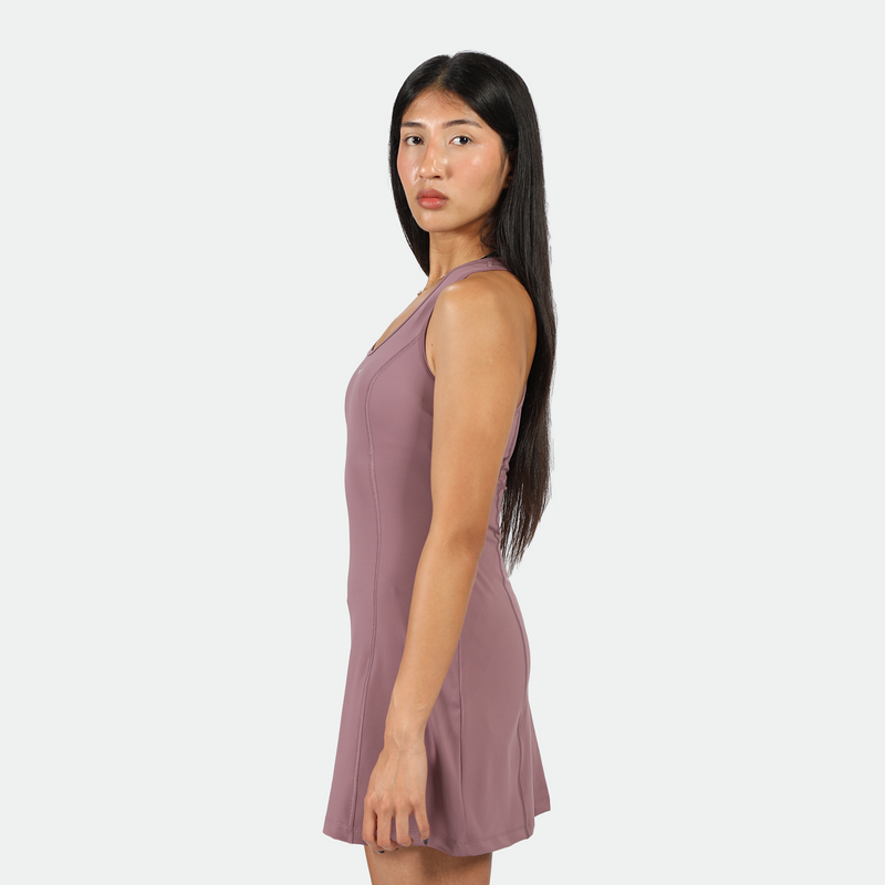 a fit woman stand at right and wearing dress purple 