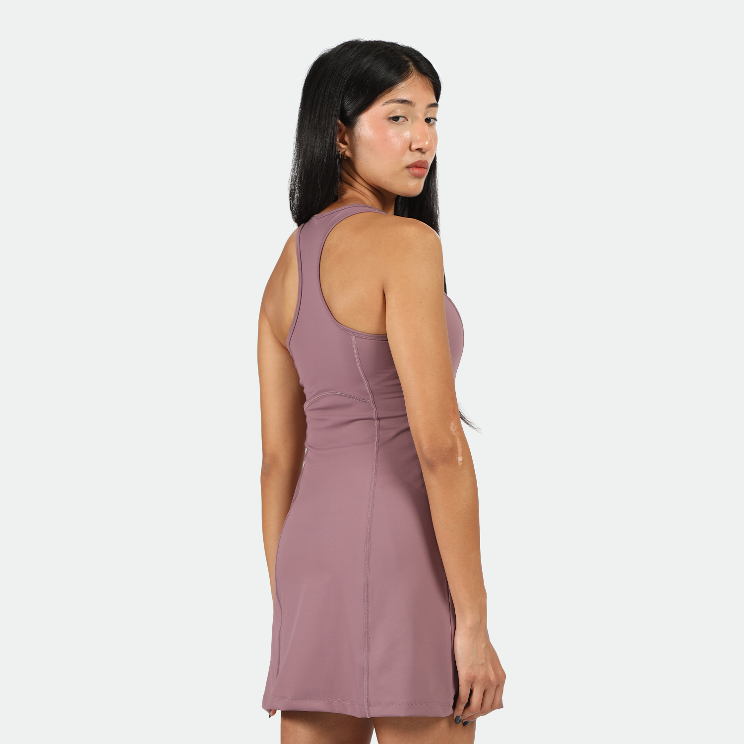 a back view for fit woman stand at right and wearing dress purple 