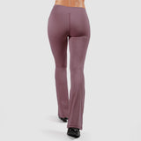 a back view for woman wearing flared legging with shoes black ,plus the background is light grey 