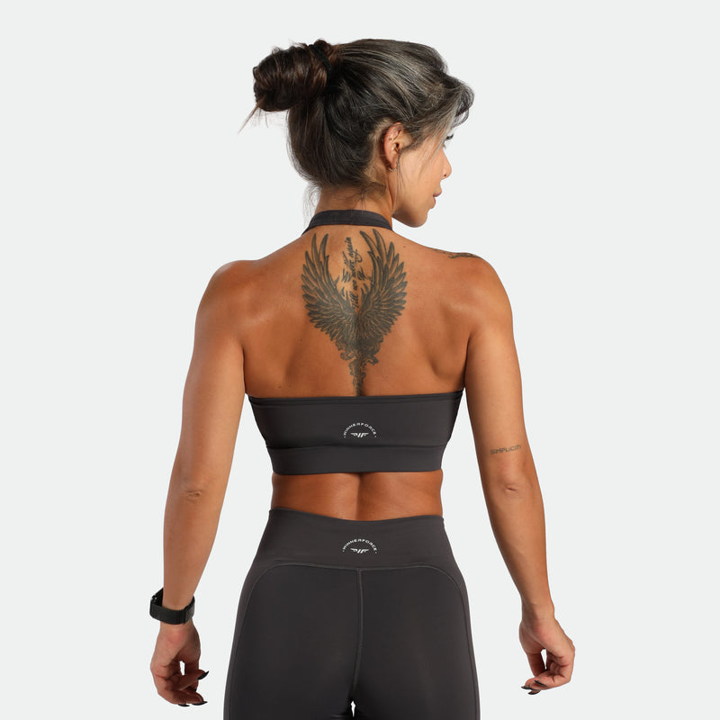 a back view for fit woman wearing matching set graphite grey ,bra and legging plus the logo