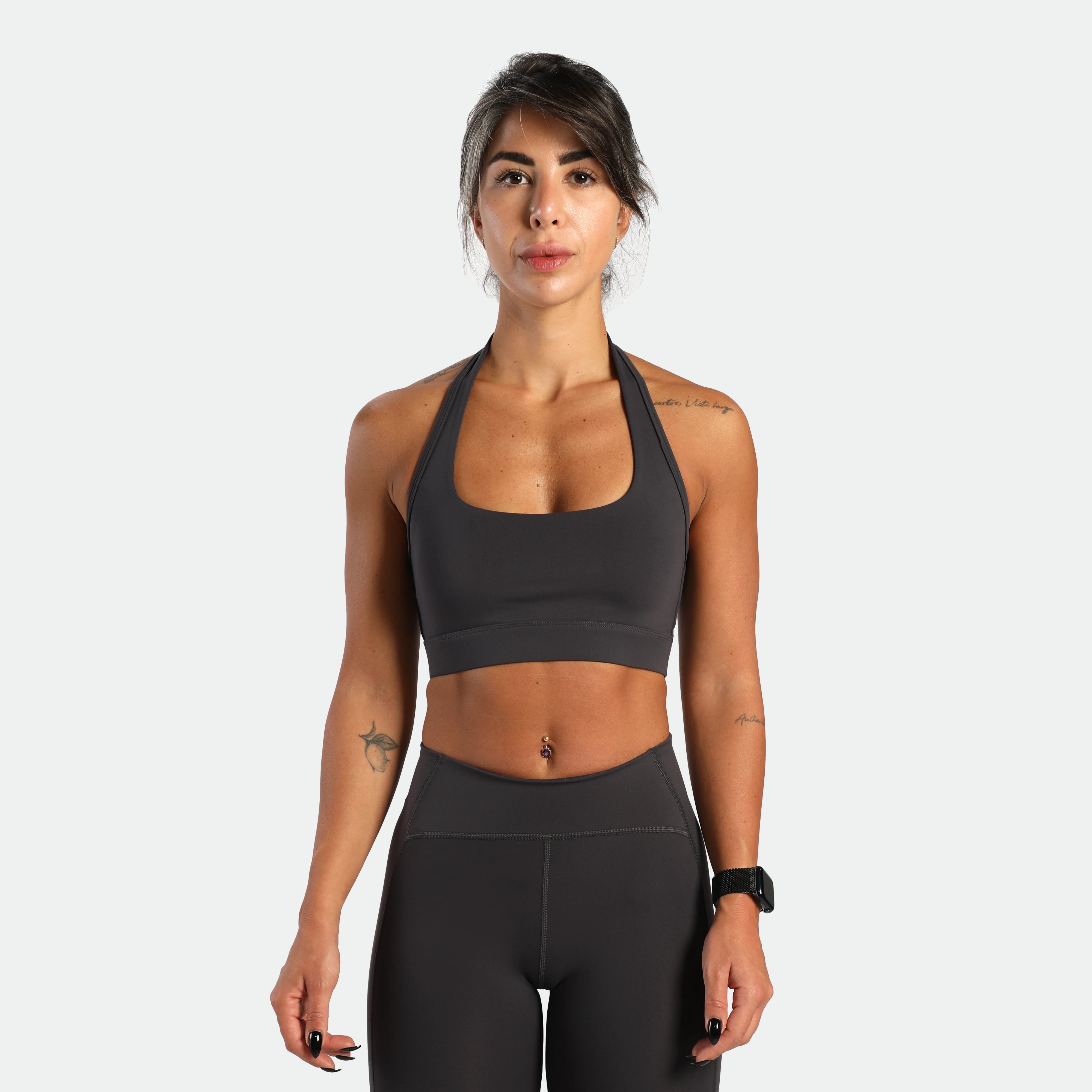 a fit woman look at the camera and she wearing matching set graphite grey ,bra and short 