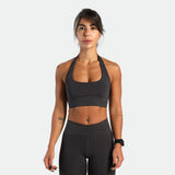 a fit woman look at the camera and she wearing matching set graphite grey ,bra and short 