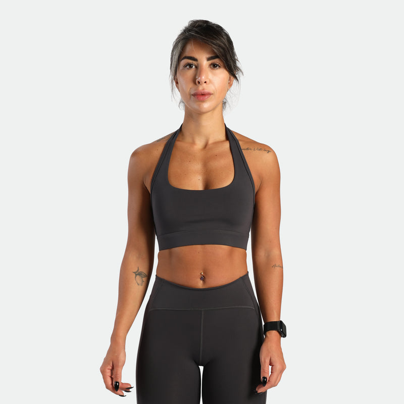 a fit woman look at the camera and she wearing matching set graphite grey ,bra and short 
