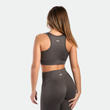 a back view for fit woman wearing matching set quite shade grey ,bra and legging 